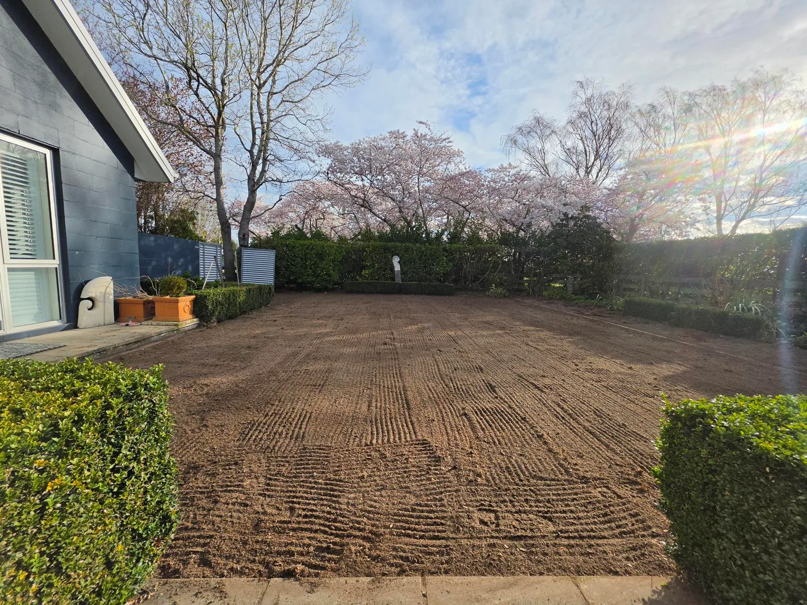 Freshly prepared lawn area with raked soil and timber garden edging along the border, Canterbury